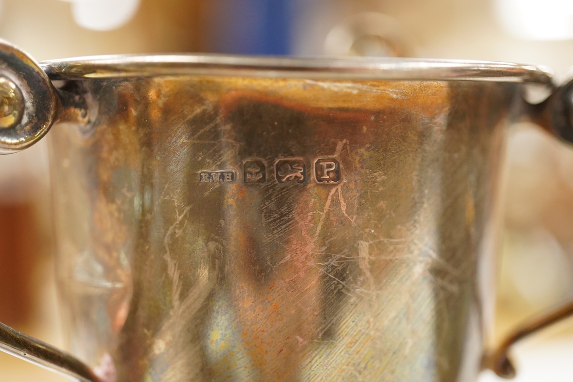 Five assorted George V silver trophy cups including two tri-handled, approx. 12.2cm and a silver bon-bon dish, with pierced border, 19.3oz.